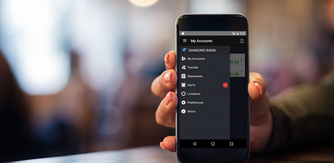 Woman's hand holding up phone showing Diamond Bank's mobile app.